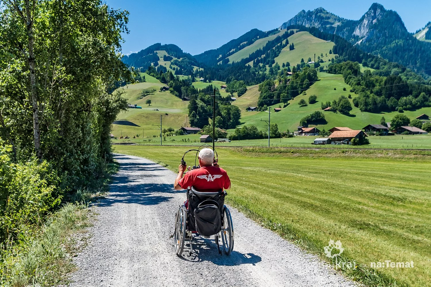 Osoba na wózku handbike na szlaku rowerowym w Szwajcarii