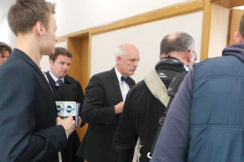 Janusz Korwin-Mikke wchodzi na salę rozpraw.