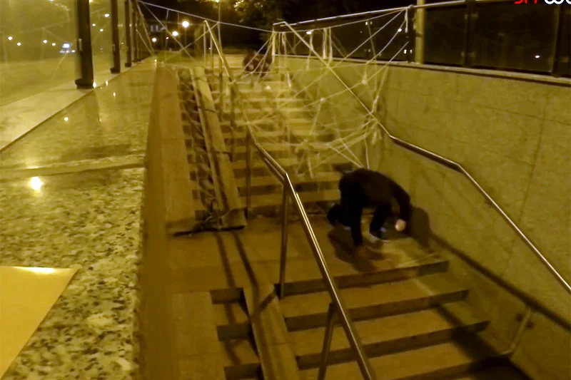 "Mutant Giant Spider Dog" i mężczyzna bliski upadku ze schodów.