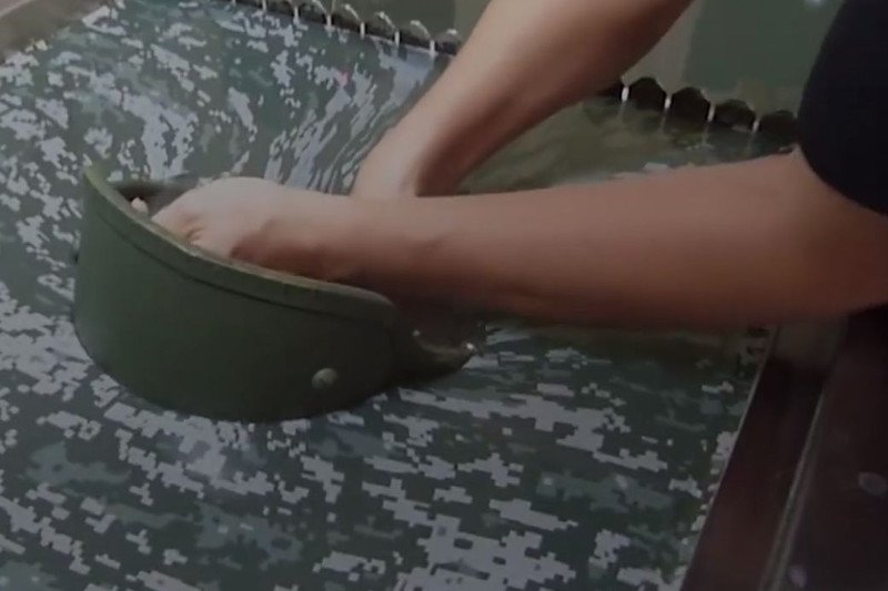 Hełm jest pokrywany barwami kamuflującymi poprzez proste zanurzenie w wodzie.