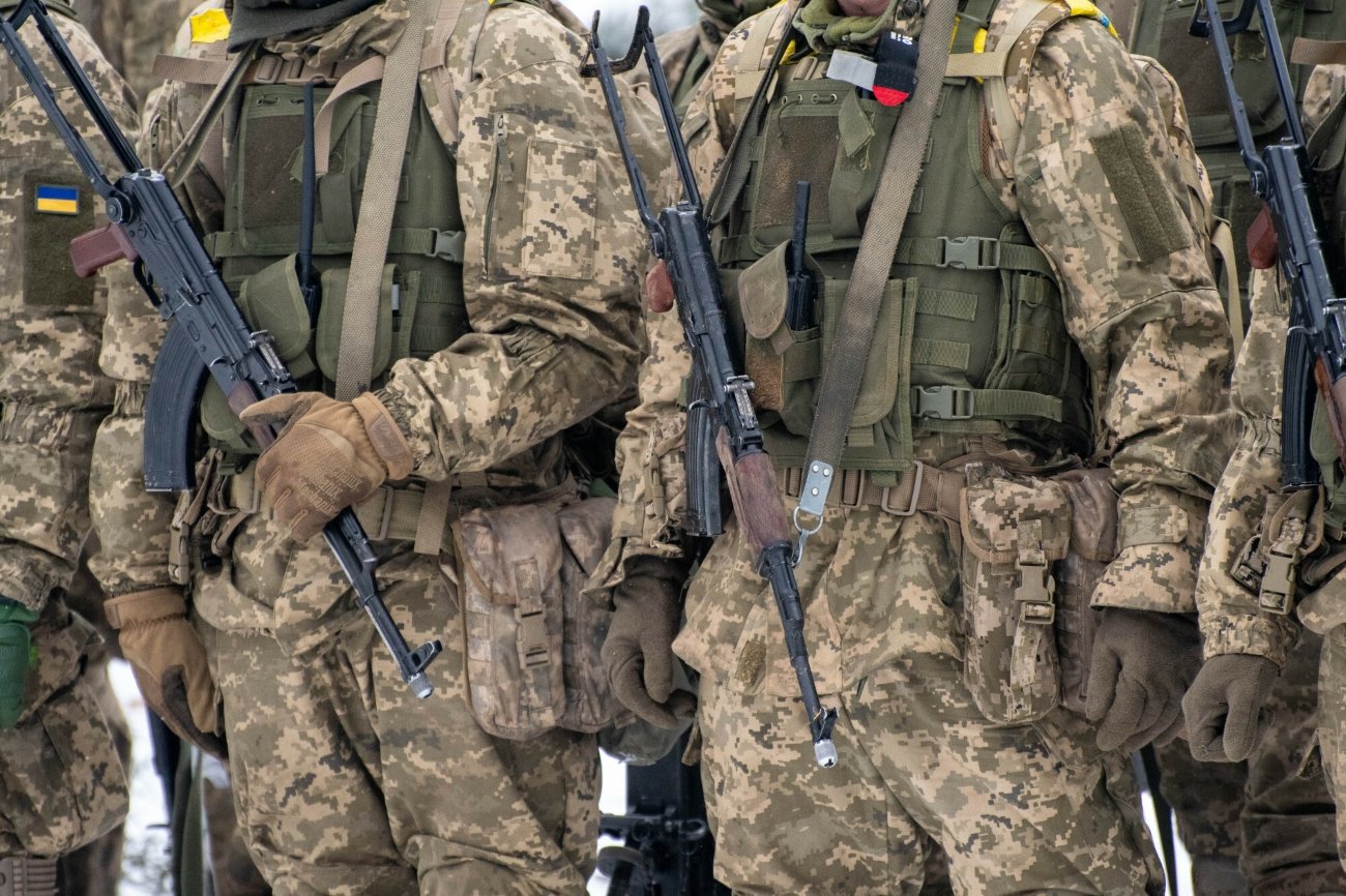 Ukraińscy dezerterzy wracają do armii. "Nie wiem, jak można to wyjaśnić". Mężczyźni w mundurach wojskowych z bronią.