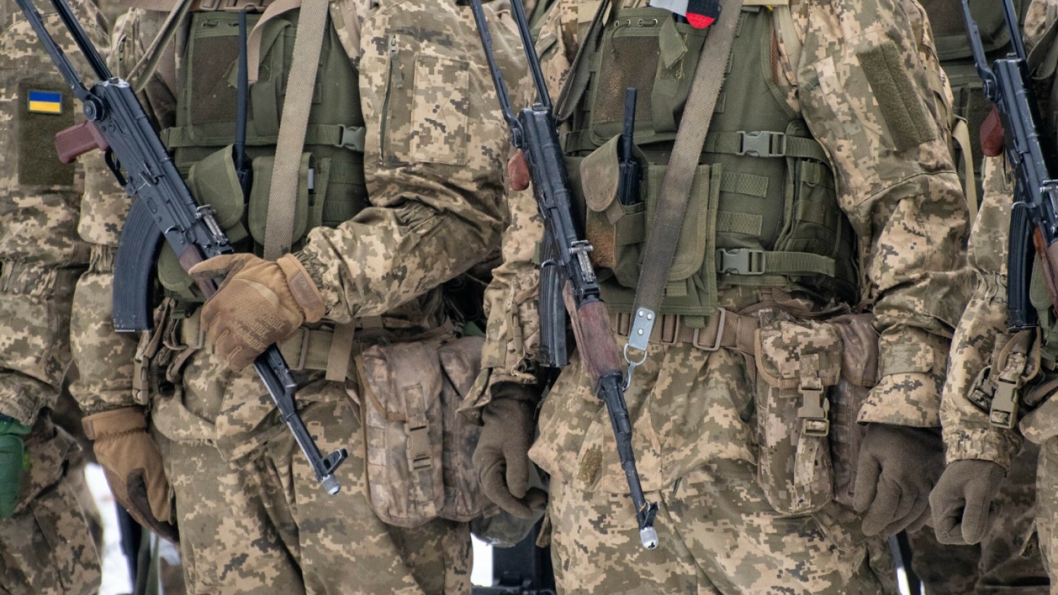 Mężczyźni w mundurach wojskowych z bronią.