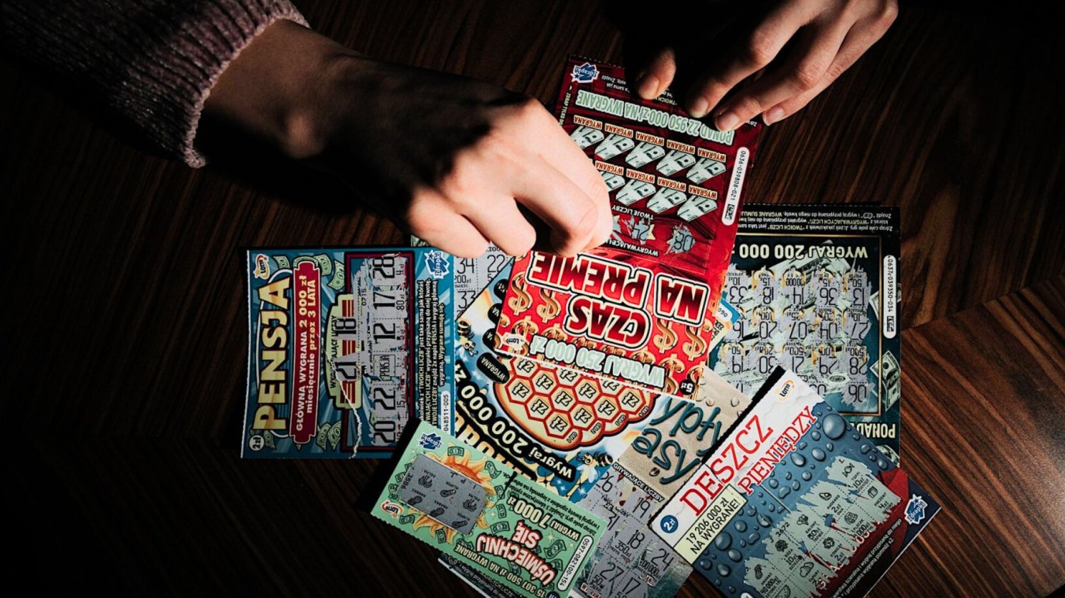 Osoba zdrapująca zdrapki Lotto