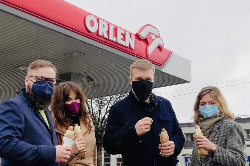 Po drodze do Siedlec posłowie Lewicy zrobili sobie przystanek na Orlenie. Zandberg i inni posłowie Lewicy pozują z hot dogami z Orlenu.