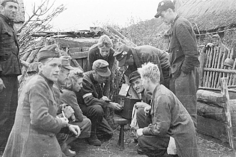 Żołnierze Kompanii Lotniczej Grupy Kampinos słuchają audycji Błyskawicy, we wsi Wiersze, około 15 września 1944 roku.