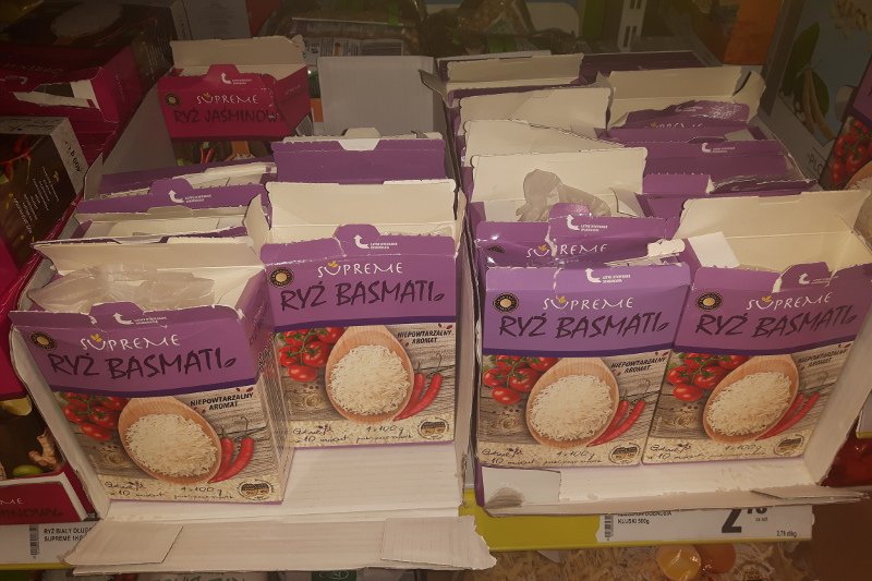 Rozerwane tekturowe pudełka, w każdym brakuje jednej lub dwóch torebek z ryżem.