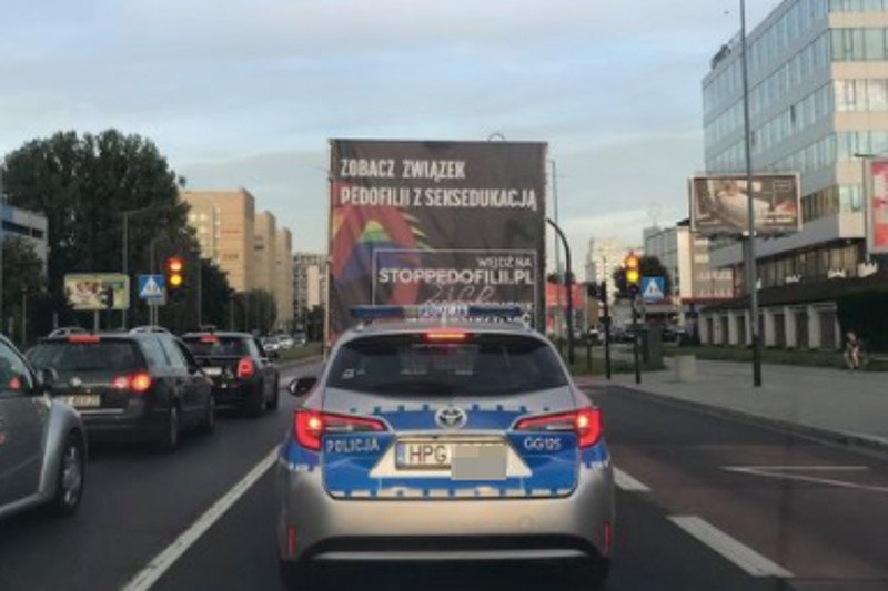 Ulicami Krakowa w eskorcie policji porusza się furgonetka anty-LGBT.