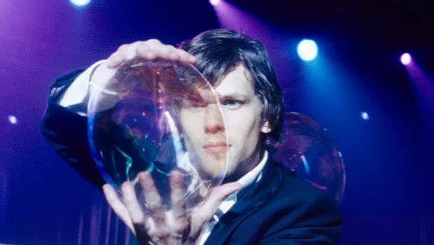 Jesse Eisenberg dmucha bańkę, do której za chwilę wejdzie Isla Fisher i będzie latać. Gdzie w tym magia?