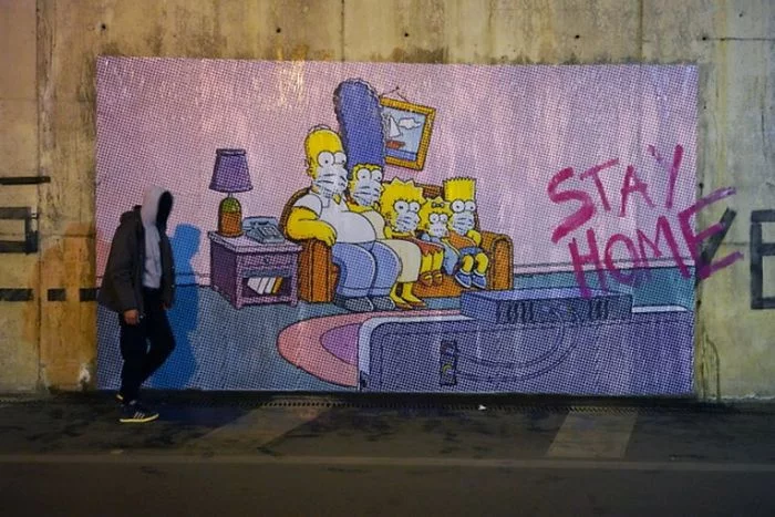 Ludzie zamknięci w domach w obawie przed koronawirusem stali się jak... Simpsonowie z popularnej kreskówki. Siedzą na kanapach, oglądają telewizor i próbują zrozumieć nową rzeczywistość, w jakiej przyszło nam wszystkim żyć. Mural Simpsonowie w czasach zarazy.