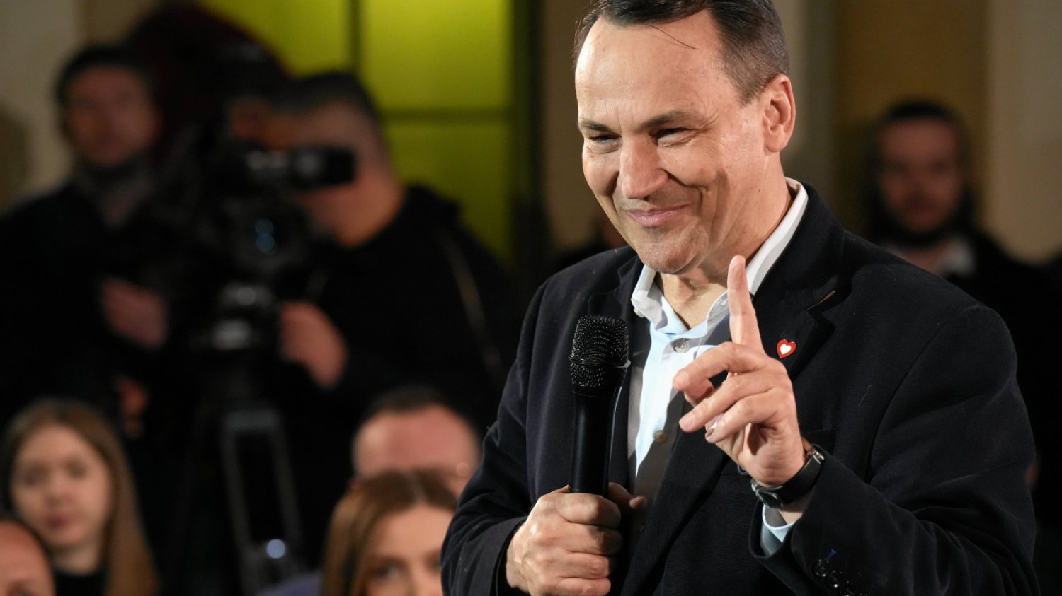 Radosław Sikorski odpowiedział Karolowi Nawrockiemu. Radosław Sikorski stojący w otoczeniu publiczności i przemawiający przez mikrofon. Unosi jedną dłoń i palcem wskazującym wskazuje w górę.