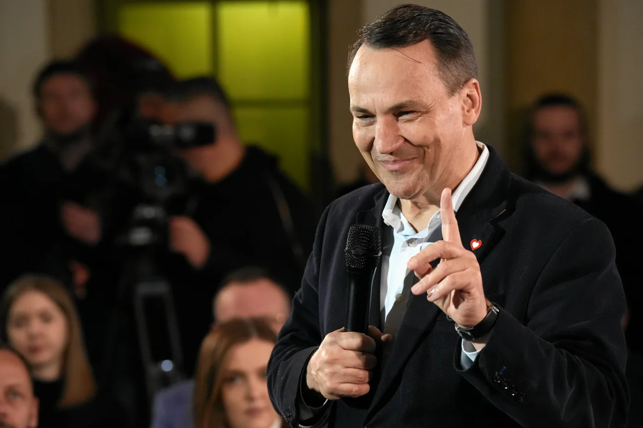 Radosław Sikorski odpowiedział Karolowi Nawrockiemu. Radosław Sikorski stojący w otoczeniu publiczności i przemawiający przez mikrofon. Unosi jedną dłoń i palcem wskazującym wskazuje w górę.