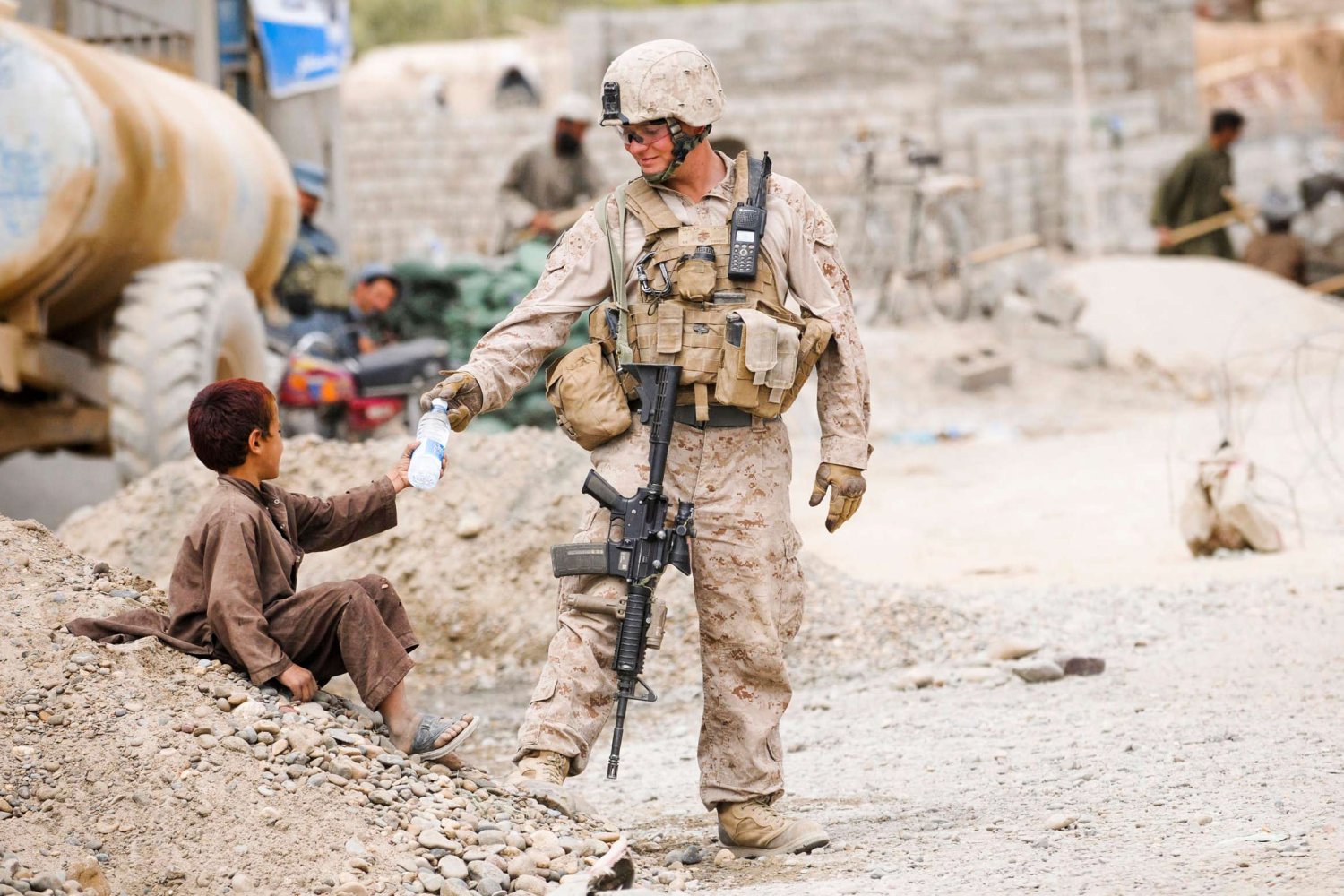 Żołnierz w Afganistanie daje dziecku wodę.