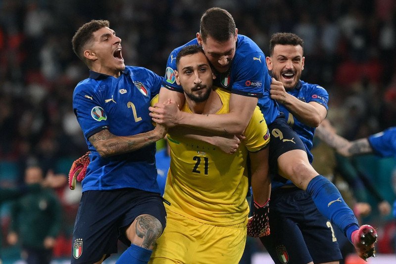 Gigio w uściskach kolegów po obronionym strzale z rzutu karnego na wagę zwycięstwa na Euro 2020