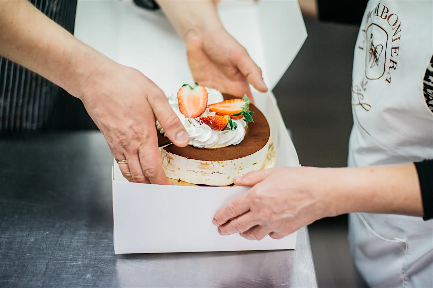 Wojtek i pracująca w cukierni Pani Ela pakują tiramisu, które zostanie pożarte w redakcji.