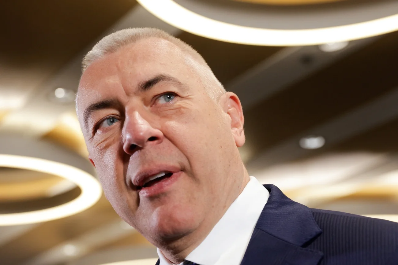 Roman Giertych w hotelu a nad nim zapalone lampy w kształcie okręgów.