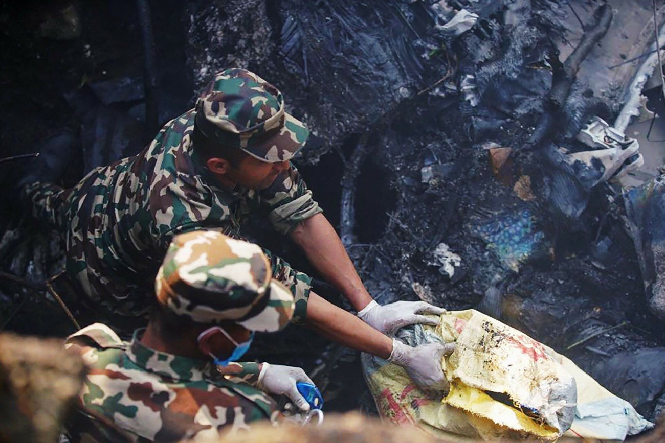 Ratownicy pracujący przy wraku samolotu, który rozbił się w Nepalu