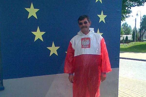 Ludwik Dziedzic w swojej patriotycznej pelerynie na tle flagi Unii Europejskiej.
