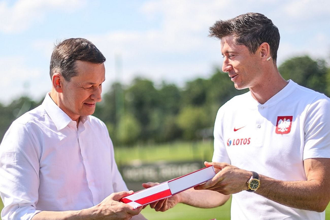 Mateusz Morawiecki odbiera pamiątkową koszulkę od Roberta Lewandowskiego