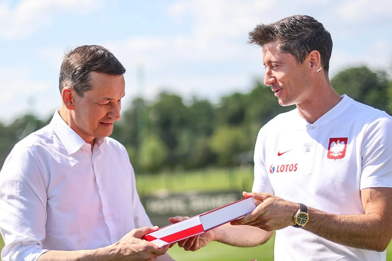 Mateusz Morawiecki odbiera pamiątkową koszulkę od Roberta Lewandowskiego