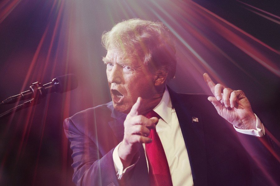 Donald Trump gestykulujący na scenie podczas wiecu wyborczego.