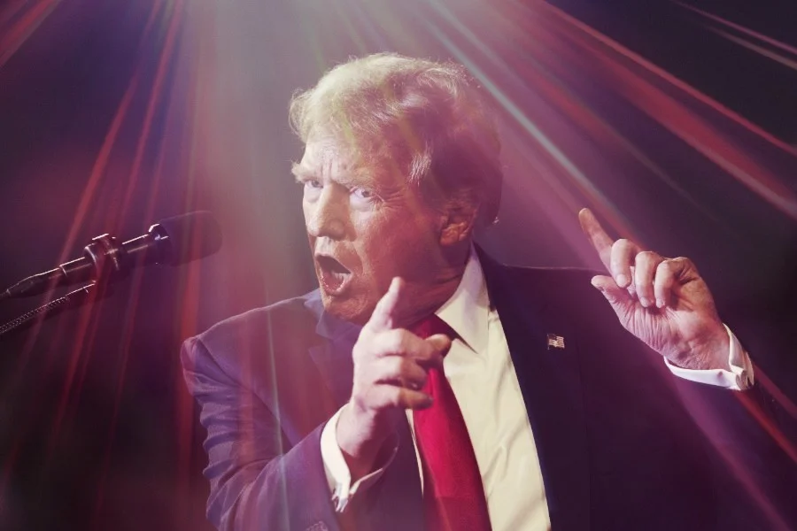 Donald Trump gestykulujący na scenie podczas wiecu wyborczego.