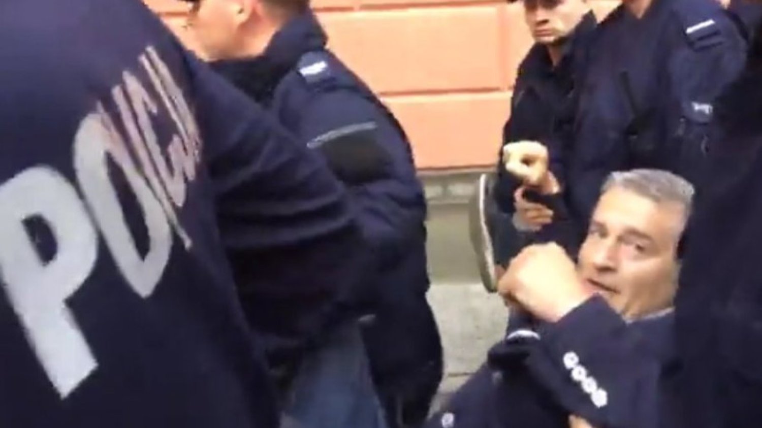 Policjanci siłą usuwają Frasyniuka, by oczyścić Krakowskie Przedmieście na wiec PiS.