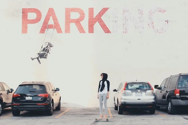 Dziewczyna na tle muralu Banksy'ego.