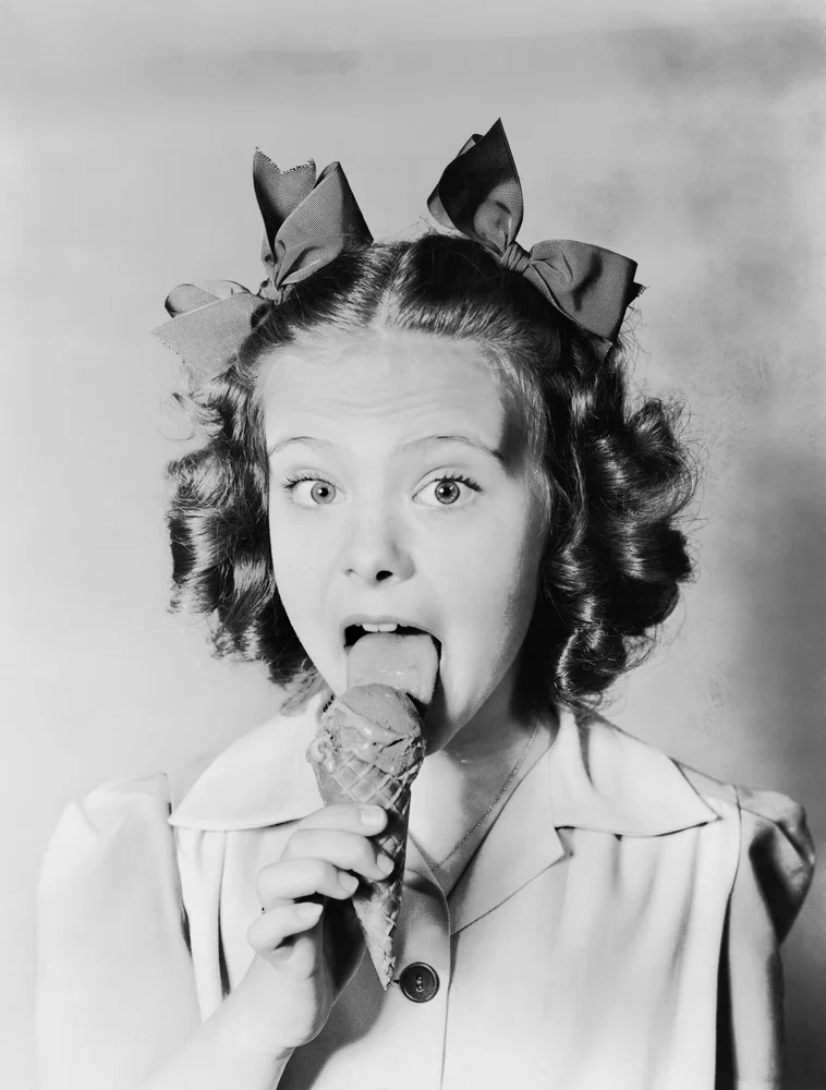 Dziewczynka z (niegrzeczną?) iskierką w oczach pałaszuje [url=http://www.shutterstock.com/pic-100022303/stock-photo-girl-licking-ice-cream-cone.html] lody w wafelku.[/url]
