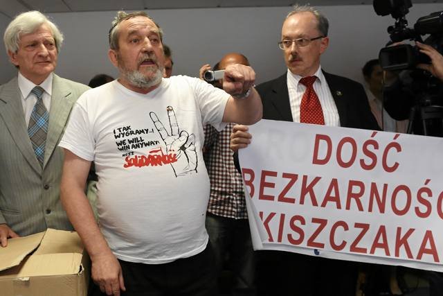 Zygmunt Miernik (w środku) dobrowolnie zgłosił się na policję. Nie potwierdził jednak, że rzucił w sędzię tortem