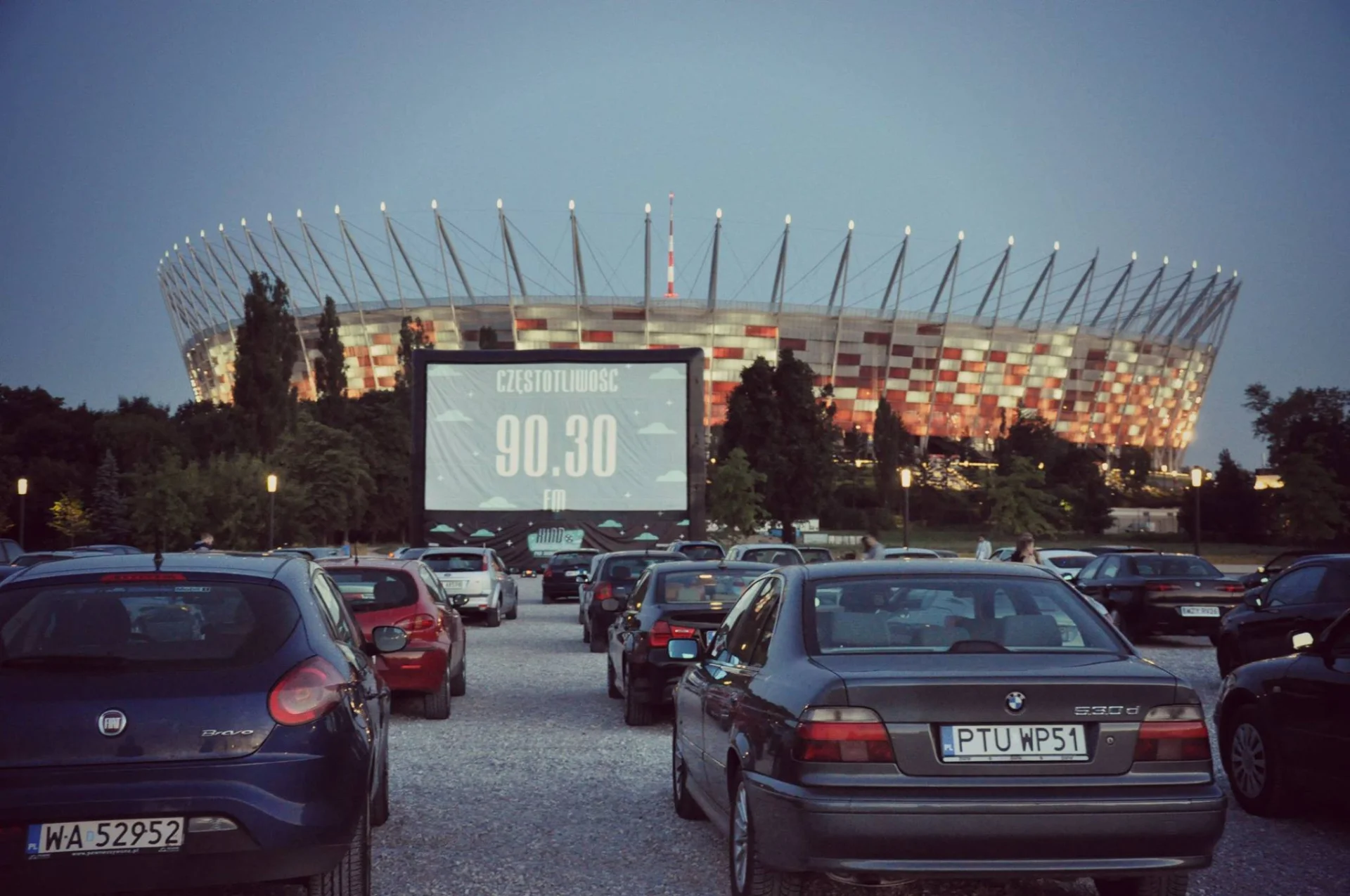 Auta parkują pod kinem na błoniach Stadionu Narodowego