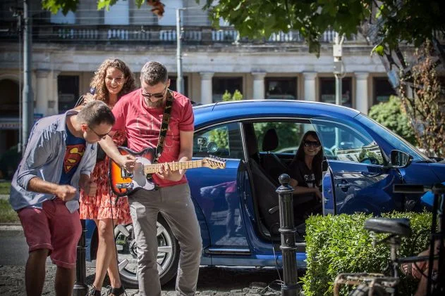 Kuba Frydrych ze swoją gitarą podłączoną do VW The Beetle