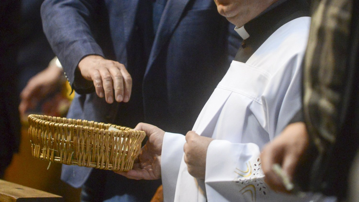 Ksiądz zbierający na tacę
