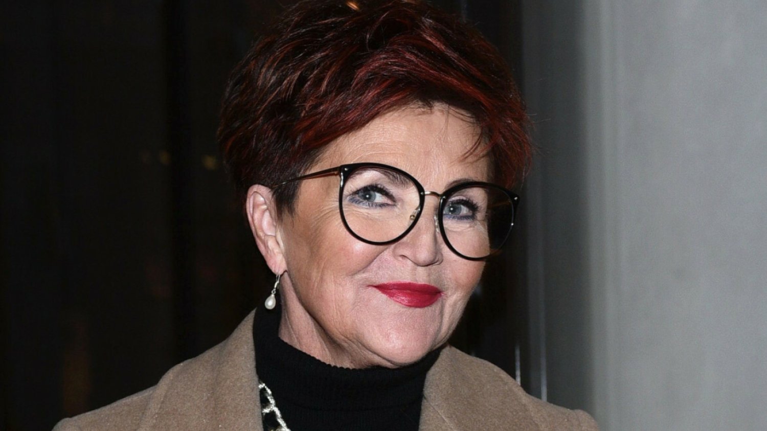 Jolanta Kwaśniewska na zdjęciu z młodości. Długie włosy i czerwona sukienka