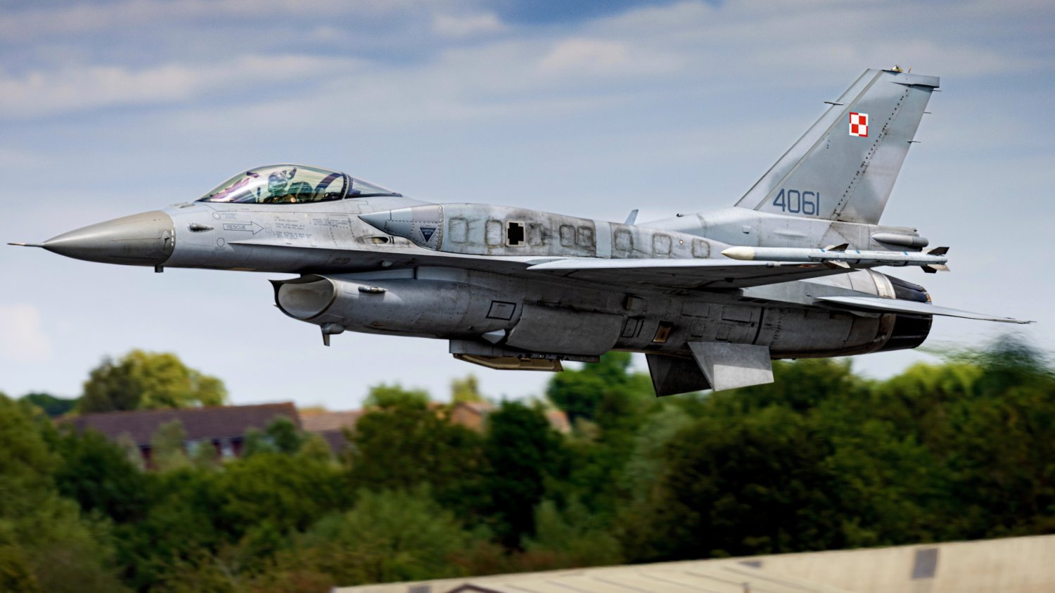 Polski myśliwiec F-16 z biało-czerwoną szachownicą w locie, obrazujący gotowość bojową Dowództwa Operacyjnego RSZ.