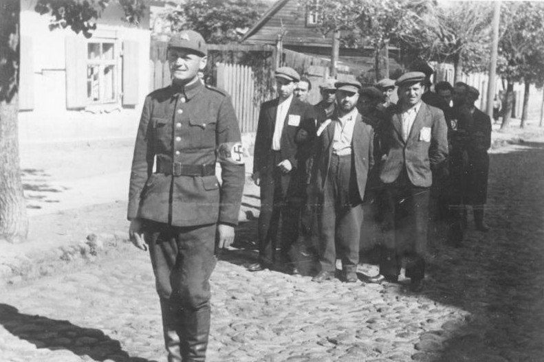 Litewski policjant (kolaborant), wyprowadzający grupę Żydów.