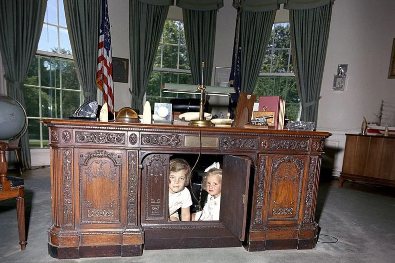 Caroline i Kerry Kennedy w biurku Gabinetu Owalnego. To jedno z kultowych zdjęć z tego miejsca.