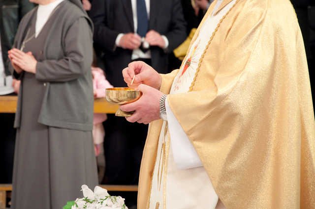 Katolicki ksiądz przygotowujący się do udzielenia komunii