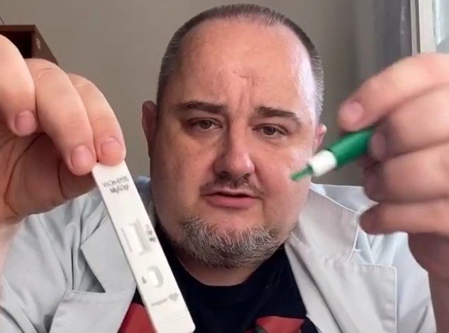 Lekarz Maciej Jędrzejko instruuje, jak wykonać test.
