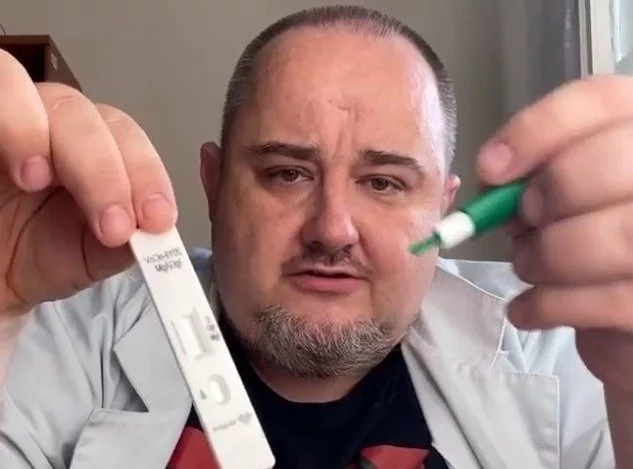 Lekarz Maciej Jędrzejko instruuje, jak wykonać test.