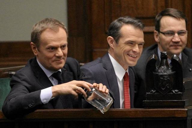 Premier Tusk trzyma słoik z pluskwą