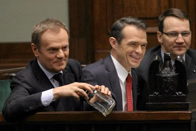 Premier Tusk trzyma słoik z pluskwą