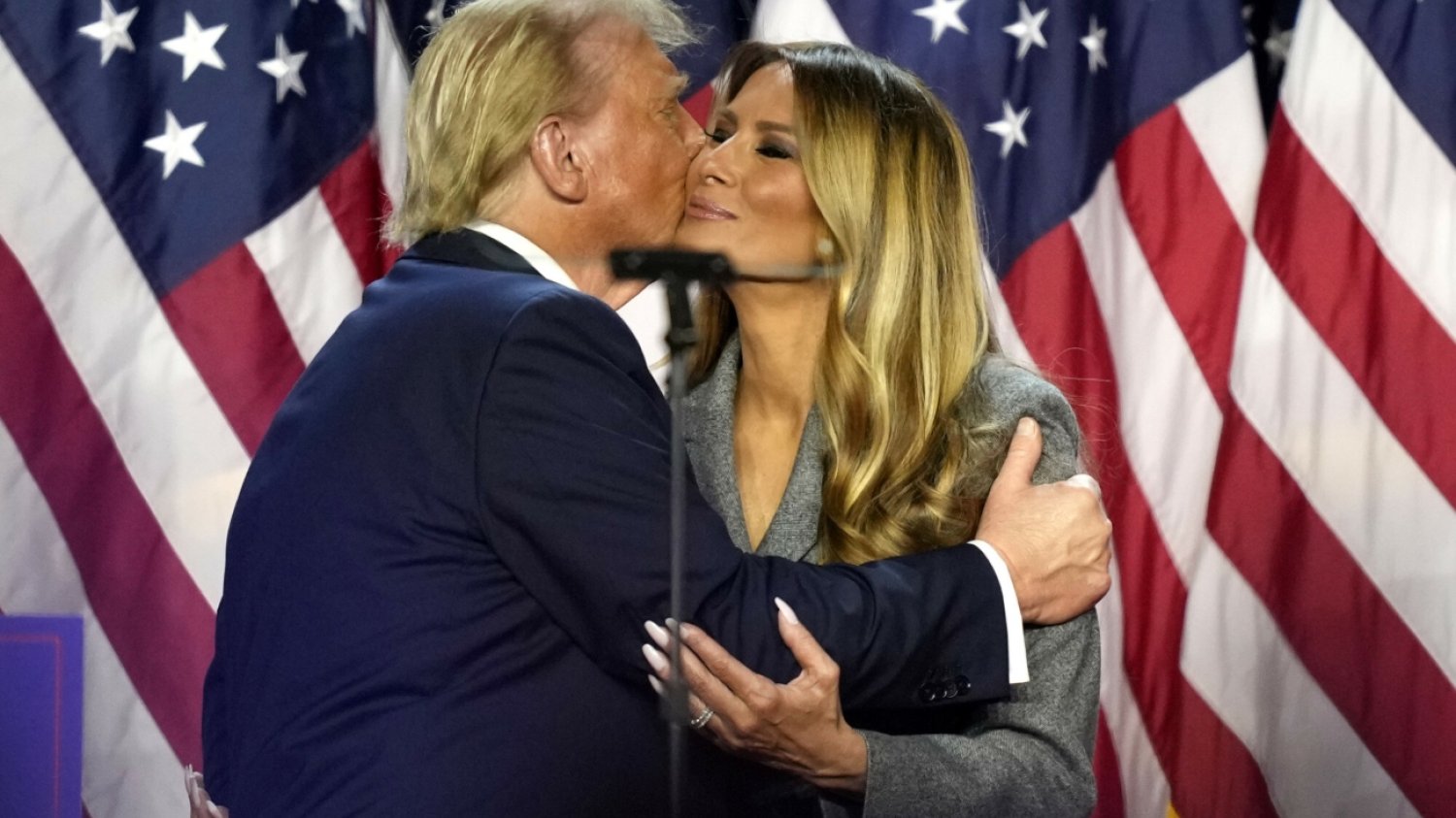 Wieczór wyborczy w USA. Melania Trump na tle amerykańskich flag dostaje pocałunek w policzek od swojego męża, następnego prezydenta Stanów Zjednoczonych Donalda Trumpa. Wieczór wyborczy w USA. Melania Trump na tle amerykańskich flag dostaje pocałunek w policzek od swojego męża, następnego prezydenta Stanów Zjednoczonych Donalda Trumpa.