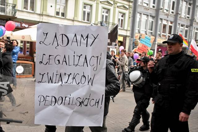 Marsz Równości w Łodzi. Policjanci odprowadzają osobę niosącą kontrowersyjny transparent