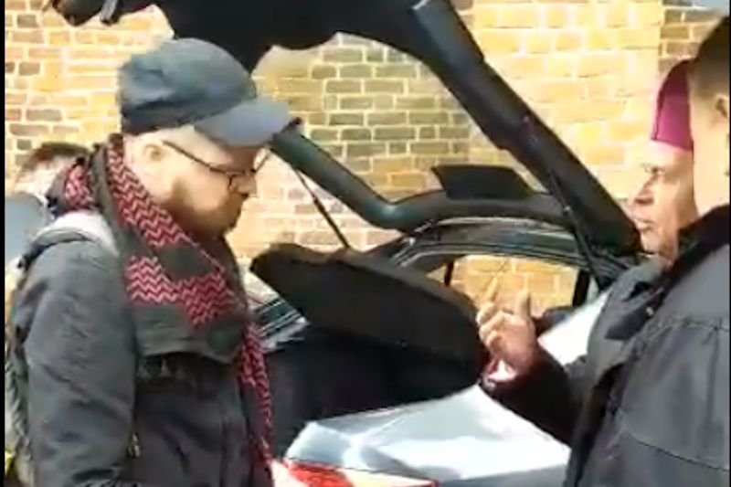 Biskup Stanisław Napierała rozmawia z dziennikarzami przed katedrą w Kaliszu.