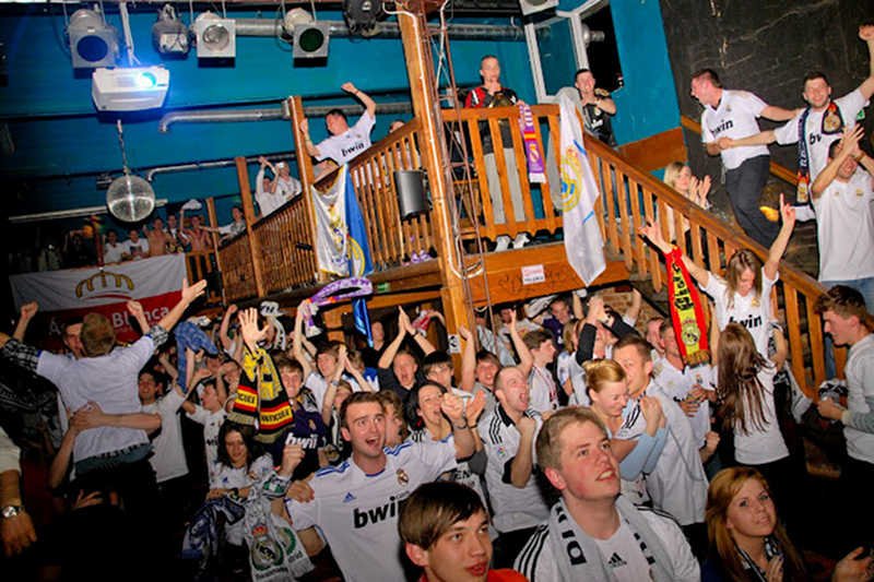 Kibice z fanklubu Realu Madryt wspólnie oglądają mecz.