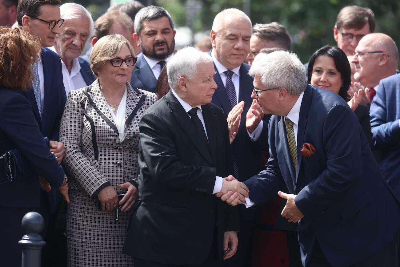Ryszard Czarnecki (europoseł PiS) ściska dłoń prezesa partii Jarosława Kaczyńskiego.