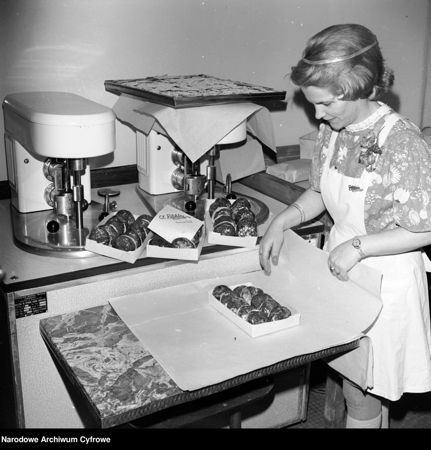 Rok 1978, sprzedawczyni pakuje pączki w papier.