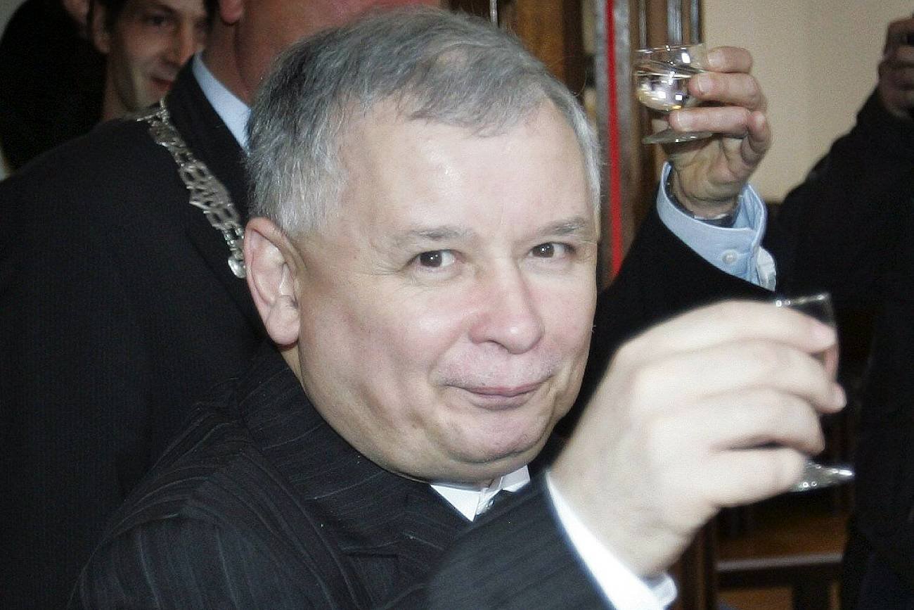 Prezes PiS Jarosław Kaczyński pijący wódkę na spotkaniu dyplomatycznym.