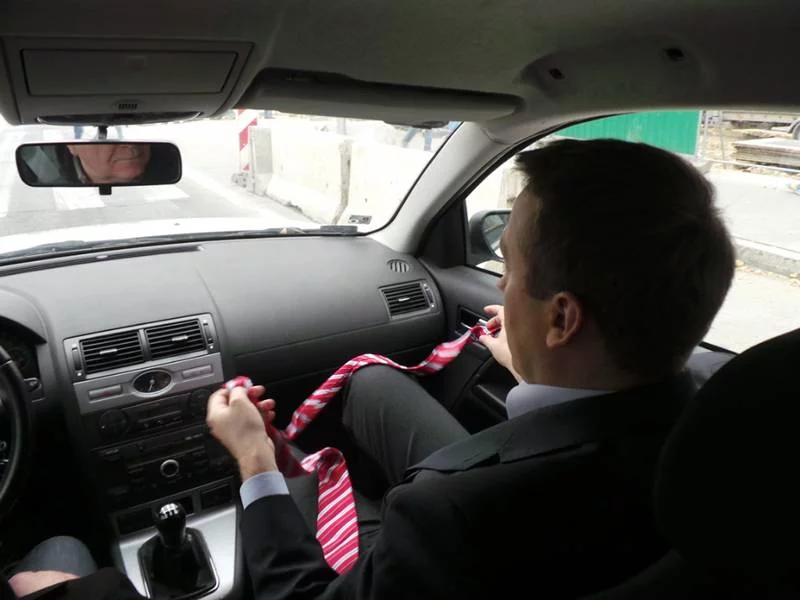 Michał Siegieda popisuje się umiejętnością wiązania krawata na kolanie