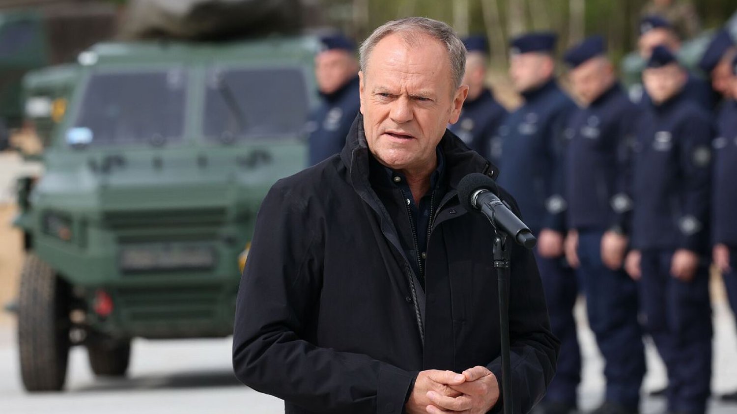 Na zdjęciu premier Donald Tusk na tle funkcjonariuszy broniących granic w czasie kryzysu migracyjnego.